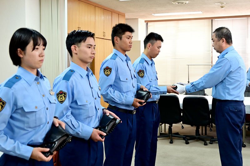 署長から新人警察官４人に拳銃が手渡された＝３日、八千代市の八千代署
