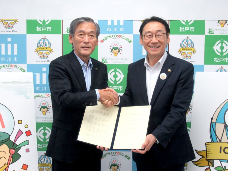行政パートナー協定を結んだ田中市長（右）と本郷谷市長＝松戸市役所