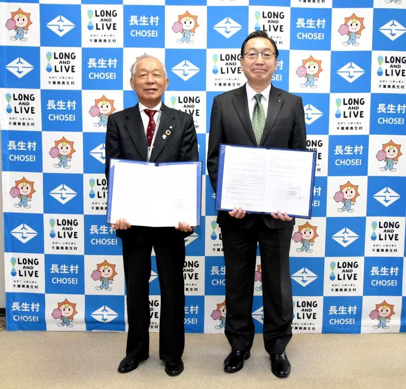協定書を持つ小高村長（左）と赤田社長＝長生村