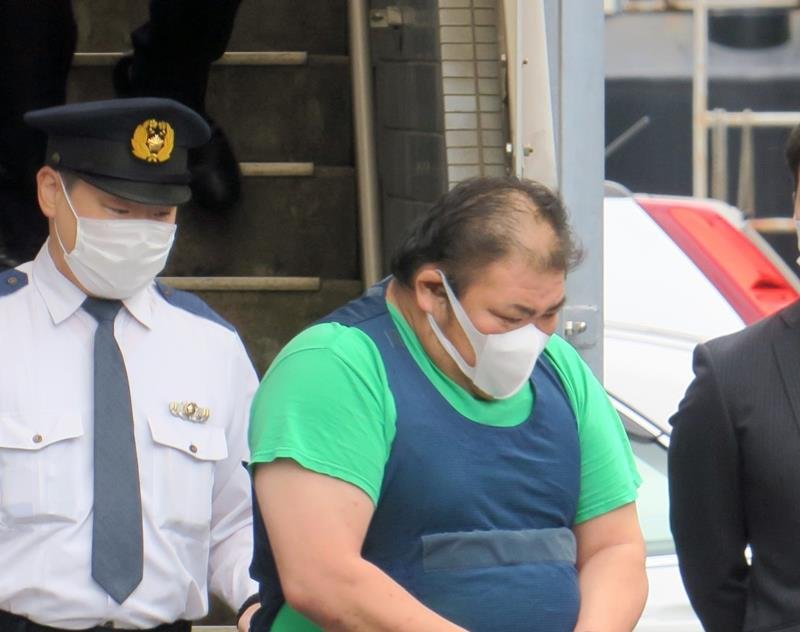 送検のため市原署を出る江川敦容疑者（右）＝１４日午後０時２０分ごろ、市原市