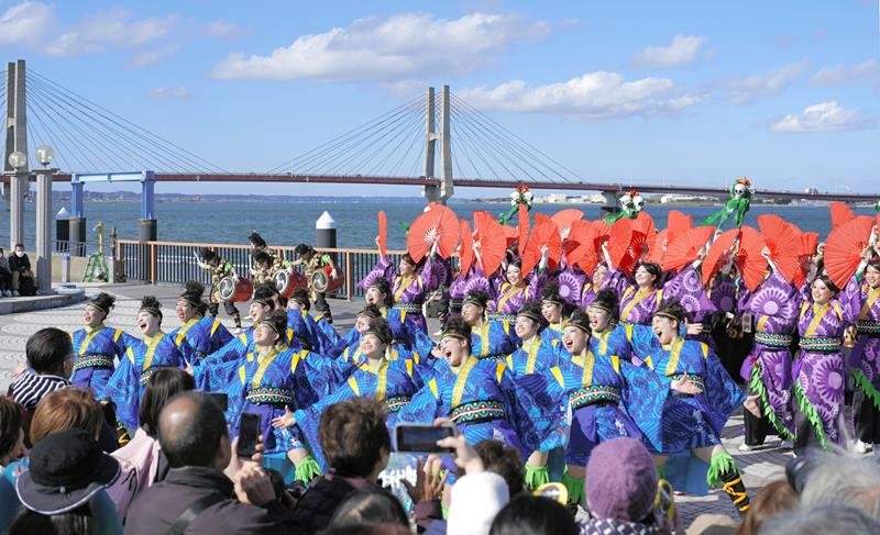 利根川をバックに演舞を披露するよさこいチーム＝２４日、銚子市