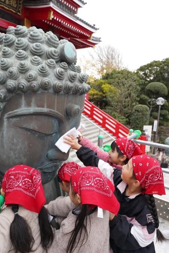 さらし布で大仏の顔を拭く園児たち＝１２月１３日、銚子市
