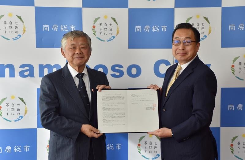 協定書を掲げる嶋田副市長（左）と赤田社長＝南房総市役所
