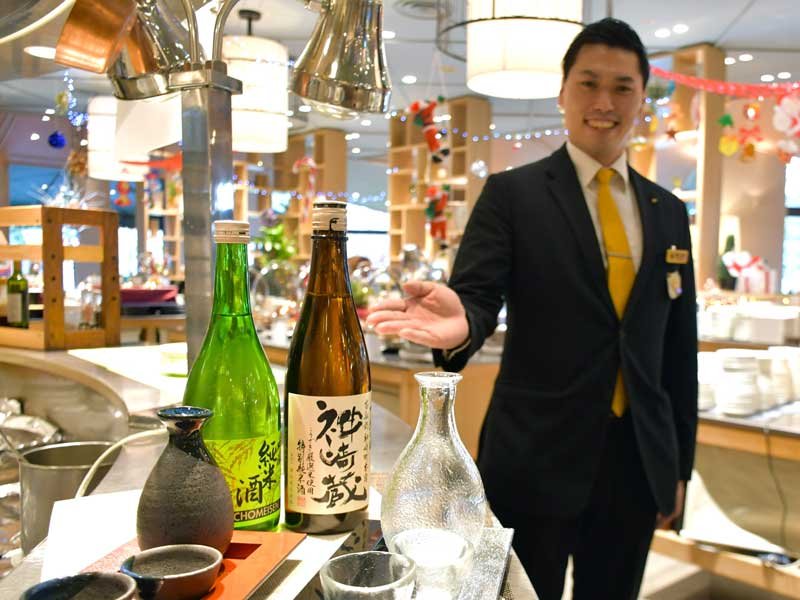 外国人観光客らレストラン利用者に提供する滝沢本店と鍋店の日本酒を紹介するホテル日航成田の押田さん＝成田市