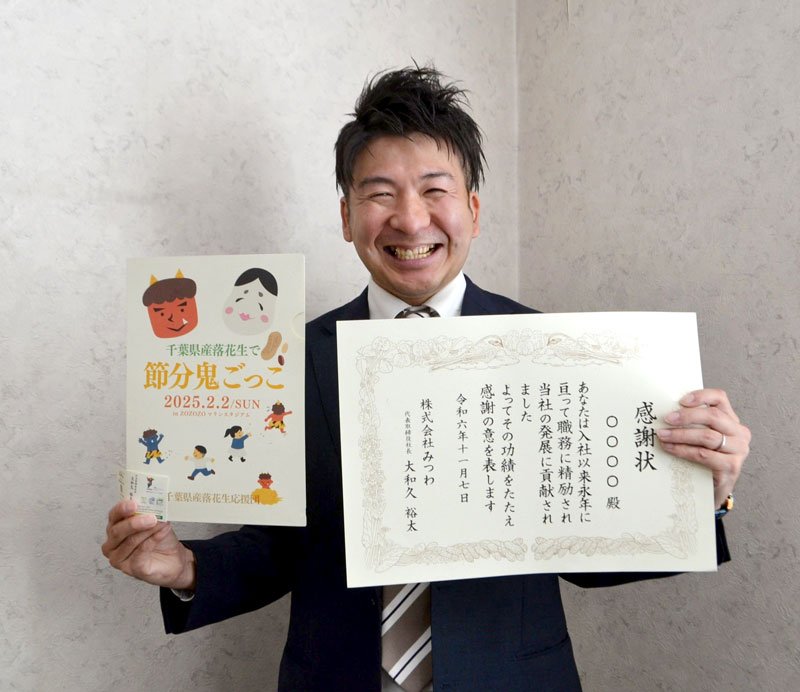 落花生の殻を活用し紙を開発したみつわの大和久社長。紙製のクリアファイル（左）や賞状などラインアップもさまざま＝千葉市美浜区のみつわ