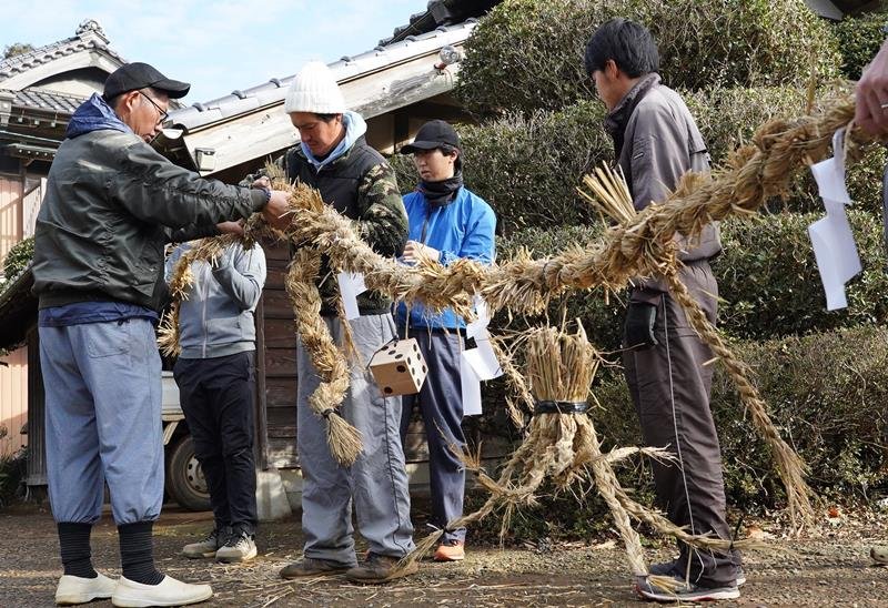 タコやサイコロなどの飾りを取り付け、しめ縄を仕上げる青年ら＝２０日、銚子市
