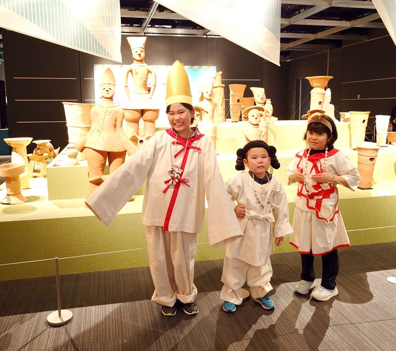古墳時代をイメージした装束を着てはにわと記念撮影する来場者＝市原歴史博物館