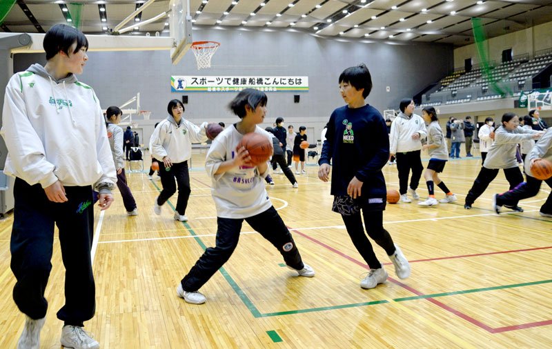 県内強豪の市船橋高女子バスケットボール部員の指導を受け、オフェンスのコツを学ぶミニバスの選手ら＝船橋市運動公園体育館