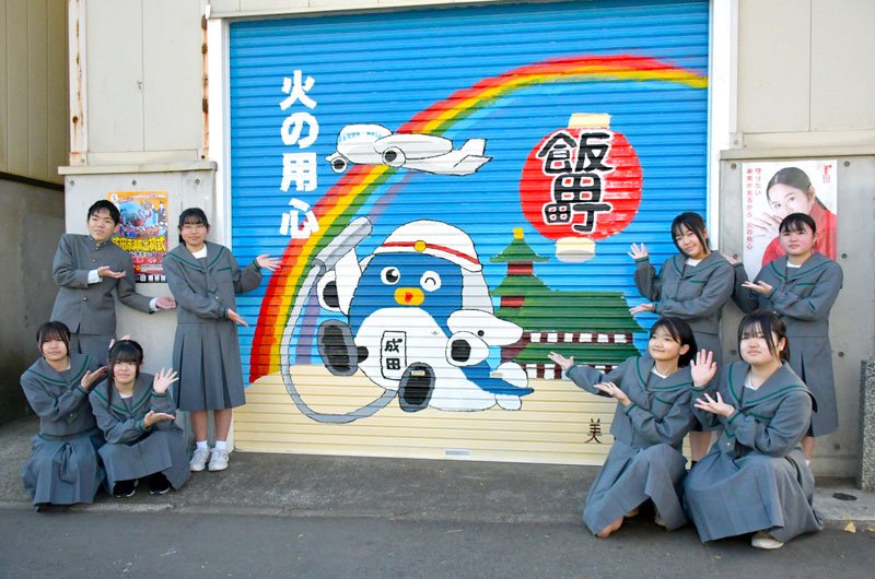 消防団の器具庫のシャッターに成田を象徴するアートを描いた西中学校美術部の生徒＝成田市