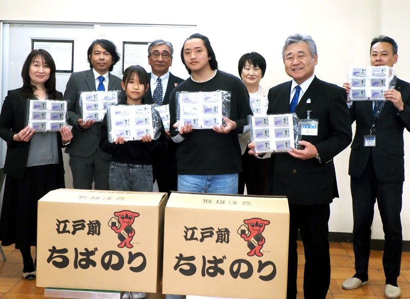 新富津漁協から贈られた味付けノリを手に喜ぶ児童ら＝富津市