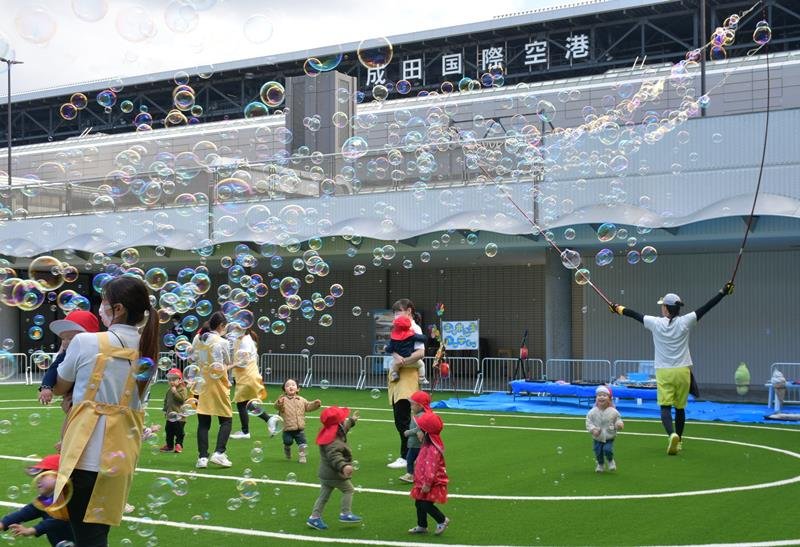 ポポパークの人工芝の園庭で楽しそうに走り回る園児ら＝成田市の成田空港