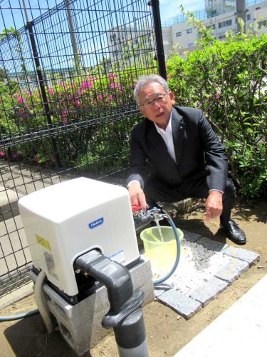 設置された災害用井戸から水を出す今野組合長＝市川市
