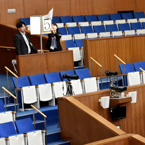 一時停止した残時間表示器（写真右下）に代わって紙を使った表示器で時間を管理する職員＝９日、千葉県議会議場