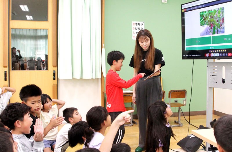 タブレットで収穫ロボットをリモート操作する児童ら＝鋸南町