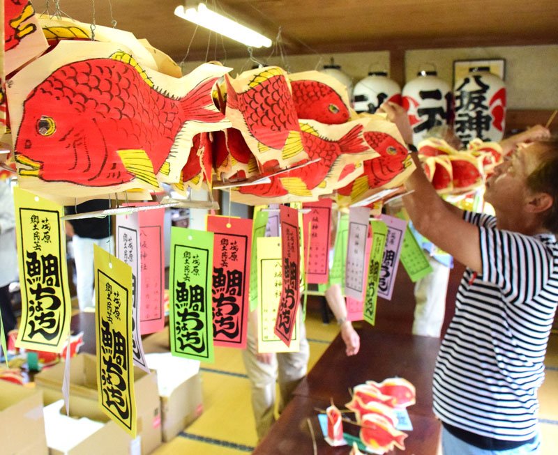 茂原市の八坂神社で２３日、夏祭りで配られる「鯛（たい）ちょうちん」作りが行われた。茂原に夏の訪れを告げる風物詩で、氏子らが丁寧に持ち手の竹を取り付けた