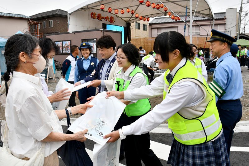 佐原の大祭の会場で香取署員らと一緒に地元の高校生がパトロールを行った＝香取市