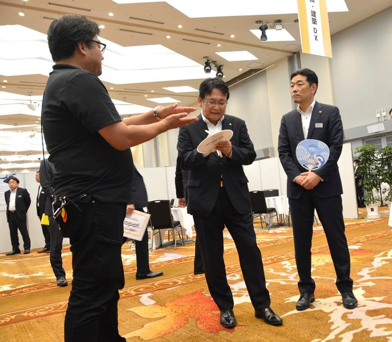 最新機器のブースを巡る神谷市長（中央）ら＝千葉市美浜区
