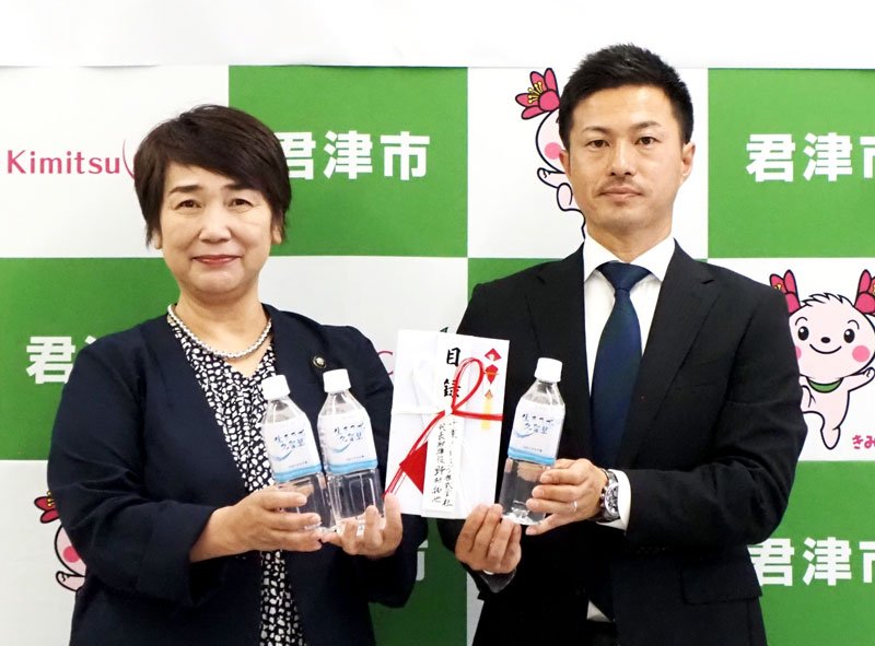 「生きた水・久留里」のペットボトルを寄贈する野村社長（右）と石井市長＝君津市