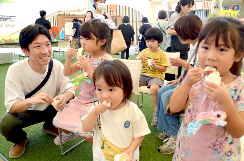 共進会で市長賞に選ばれた中村さんの梨を試食する家族連れ＝１６日、アリオ市原