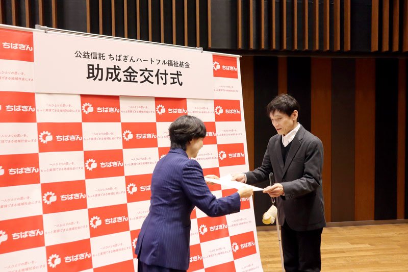 淡路専務から贈呈書を受け取る団体代表者＝千葉市中央区
