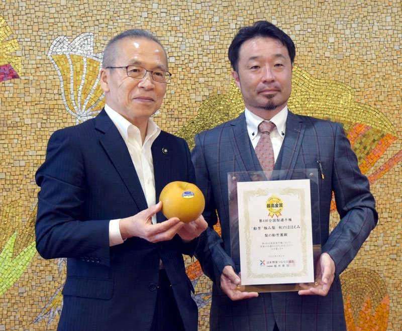 全国梨選手権で最高金賞を獲得した船芳園の加納さん（右）。左は「秋のほほえみ」を手にする松戸市長＝船橋市役所