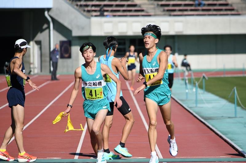 ６区の小池翔太（右）からたすきを受け取ったアンカー中村碧吹
