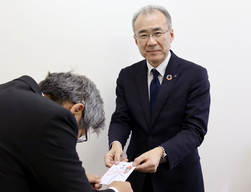 寄付金を託す有賀推進本部長（右）
