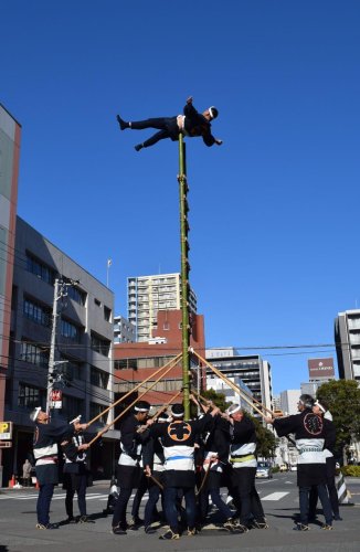はしごの上で妙技を披露する鳶職人＝６日、船橋市
