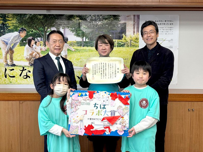 井崎市長（後列左）に「ちばコラボ大賞」特別賞受賞を報告した「流山防災まちづくりプロジェクト」の矢口代表（中央）と子ども防災チーム「ミラクリンズ」のメンバーら＝流山市役所