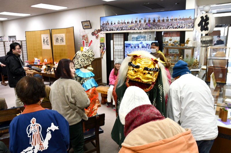 佐原町並み交流館で、来場者の頭をかむしぐさをする獅子＝１０日、香取市