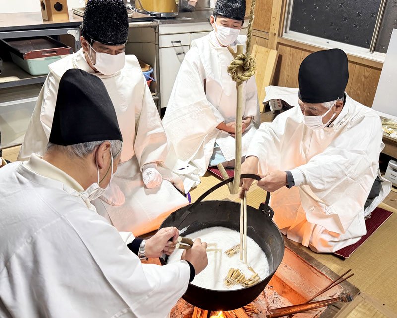 葦の束が入った粥を煮込む神職ら。奉納後、詰まった粥の量で農作物の豊凶を占った＝１５日未明、袖ケ浦市
