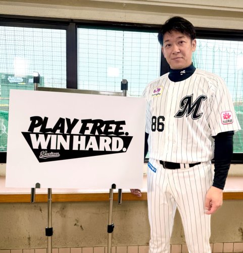 今季のスローガン「ＰＬＡＹ　ＦＲＥＥ．　ＷＩＮ　ＨＡＲＤ．」が記されたボードの横に立つ千葉ロッテ・サブロー監督