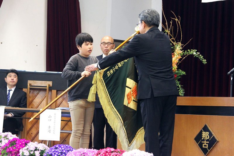 那古小学校の校旗を返納する５年生の鈴木さん（左）＝１９日、館山市