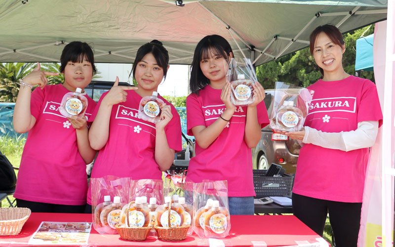 「白子たまねぎ祭り」でお披露目されたソース「たまんねーぎ」を手にアピールする（右から）片岡さん、露崎さん、鶴岡さん、佐藤さん＝５月１０日、白子町