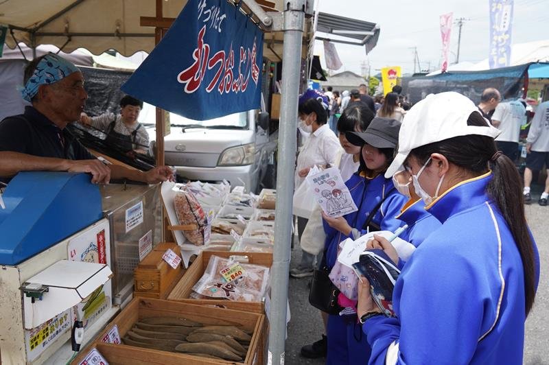 朝市会場で出店者にインタビューするジャージ姿の中学生（右）＝いすみ市
