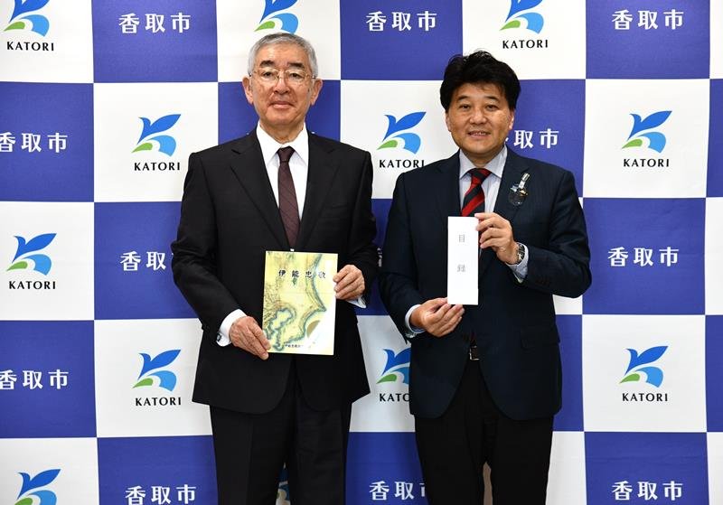 伊能忠敬の資料本を伊藤市長（右）に手渡す坂本会長＝香取市役所