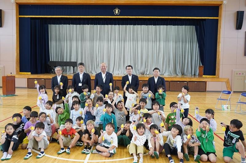 贈呈式で防犯ブザーを持つ児童と、ＪＡいすみやいすみ市の関係者ら＝同市
