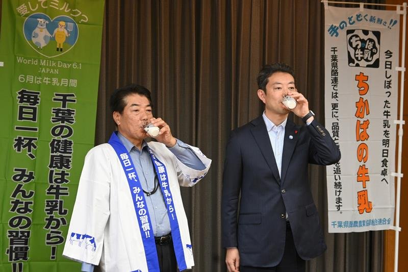 千葉県酪農農業協組連合会の高橋会長（左）から手渡された牛乳を飲む熊谷知事＝１０日午前、県庁
