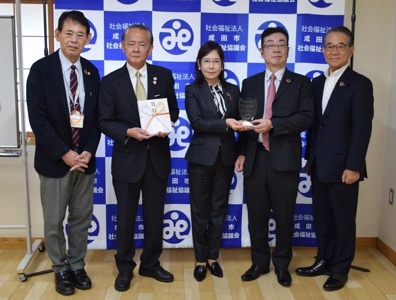 目録を手にする山田会長（左から２人目）と佐久間会長（同３人目）と大木社長（同４人目）＝成田市
