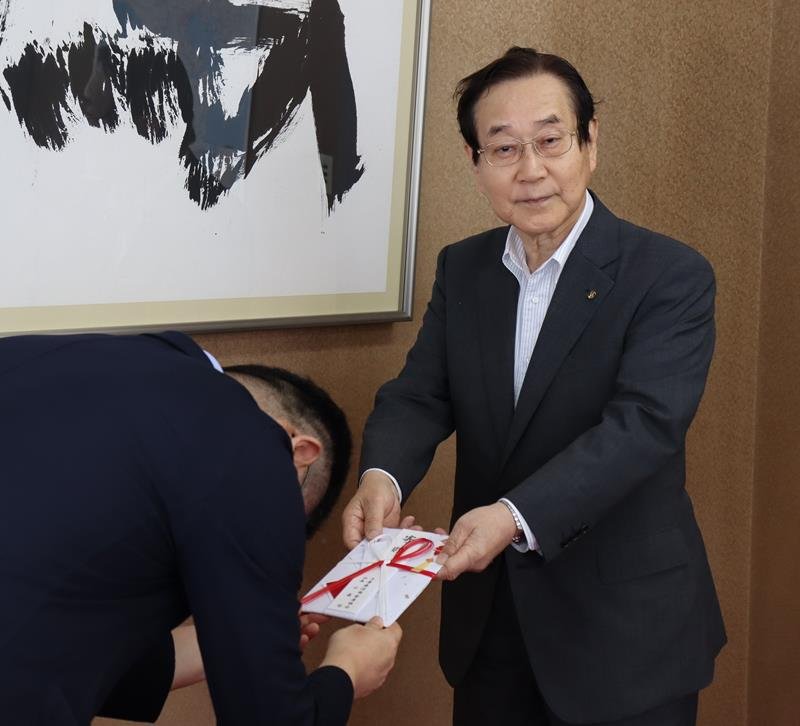 寄付金を手渡す千葉県信用金庫協会の小森哲会長（右）
