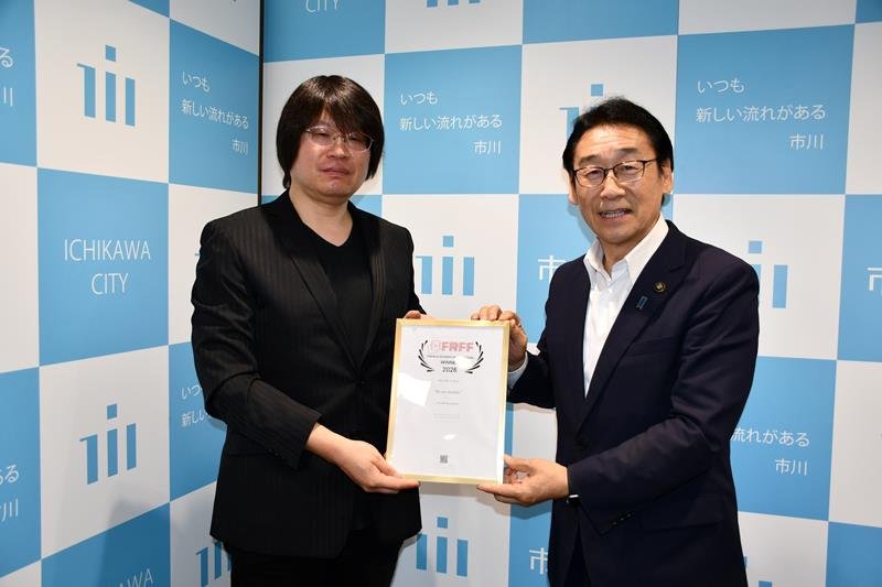 「フレンチ・リビエラ映画祭」で受賞した草森さん（左）。右は田中市長＝市川市役所
