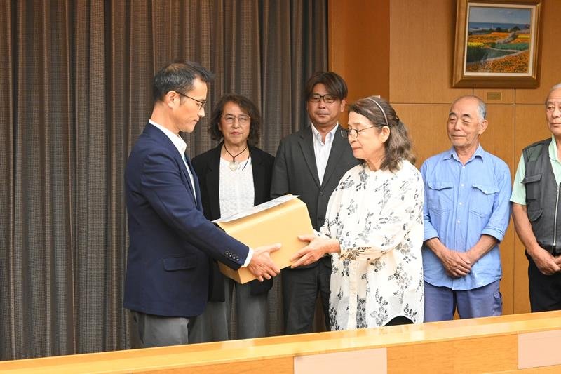 署名を県に提出する勝又代表（手前右）＝２４日午後、千葉県庁
