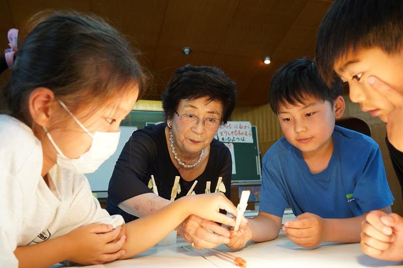 講師の照川市長（左から２人目）と羽化を観察する児童＝勝浦市