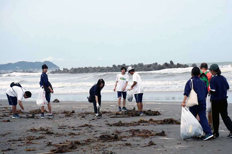 砂浜のごみを拾い集める生徒ら＝いすみ市