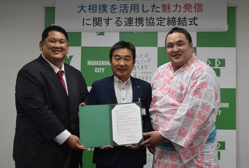 協定書を手にする宮本市長（中央）と阿武松親方（左）、阿武剋関＝習志野市役所
