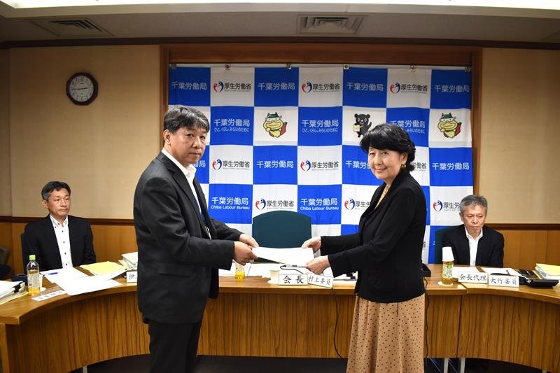 千葉地方最低賃金審議会の村上会長（右）に諮問書を手渡す千葉労働局の小山局長＝２日、千葉市中央区の県教育会館
