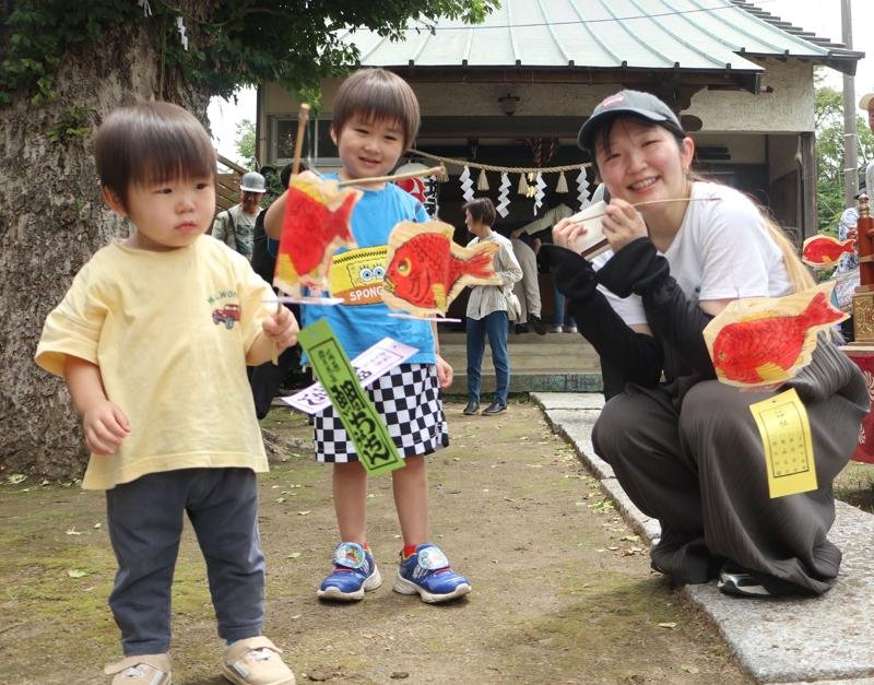 鯛ちょうちんを受け取って笑顔の親子＝４日、茂原市茂原の八坂神社