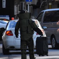 不審物のバッグを運ぶ警察官＝２８日午前１１時５分ごろ、千葉市中央区の京成千葉中央駅付近
