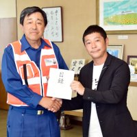 館山市の金丸謙一市長（左）に目録を手渡す前澤さん（同市提供）