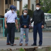 捜査員に連れられて現場検証する梅沢容疑者＝７月、八街市